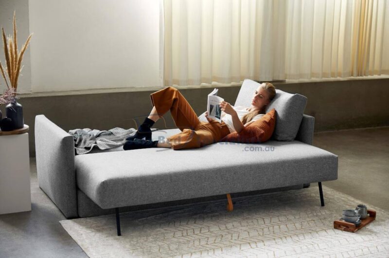Woman lying down, reading on the Sydney Storage with Arms Sofa Bed opened up as a bed